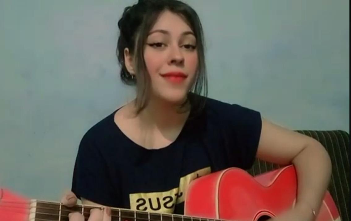 Renata Pattez sorrindo com violão